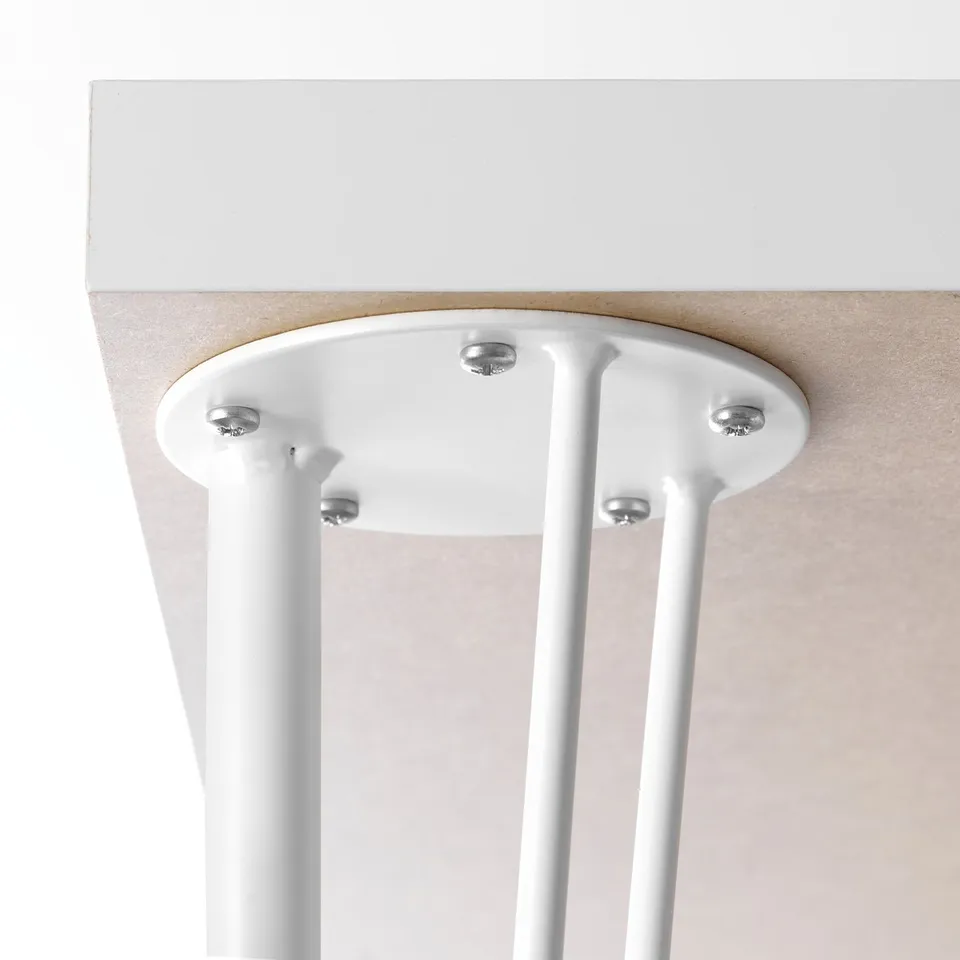 A close-up of a tables underside, highlighting a robust mounting plate secured by four screws to sturdy, cylindrical legs.