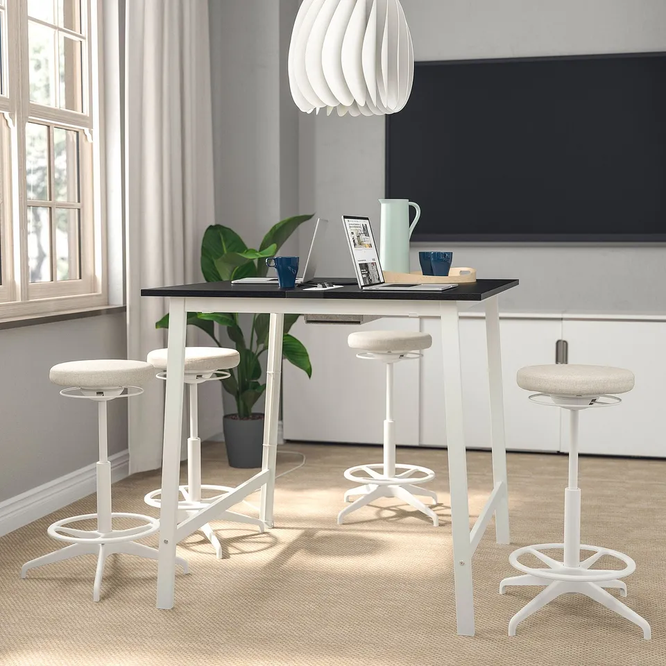 Modern MITTZON white office setup with four white stools, sleek black tabletop, and trendy light fixture, spacious and stylish.