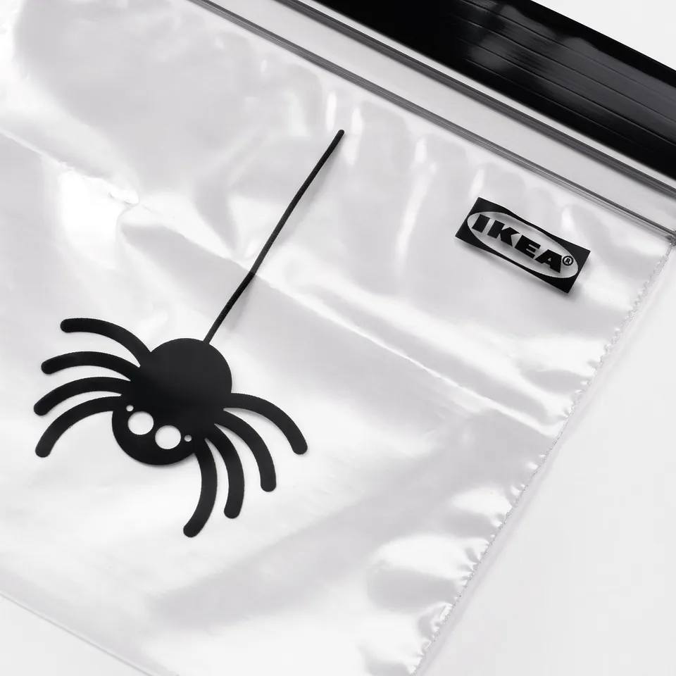 Clear plastic bag with black spider decoration, IKEA label.