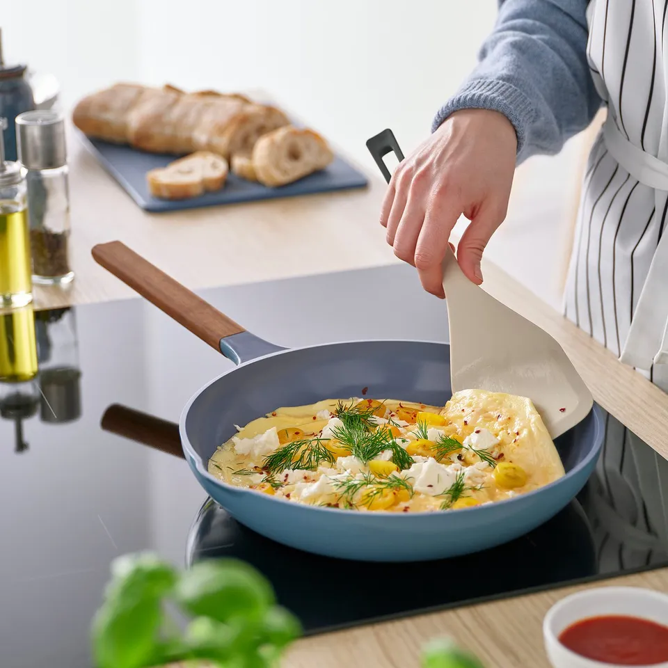 Flipping food with spatula in frying pan.