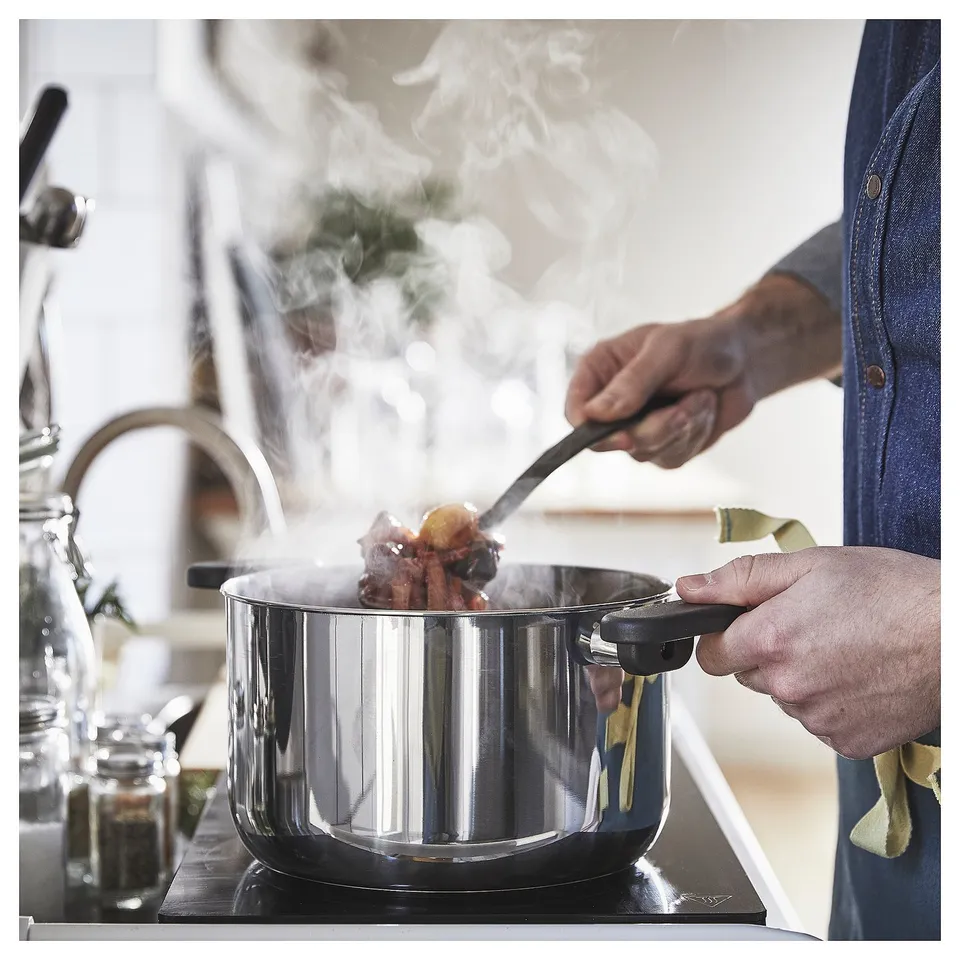 Stir-fry with tongs, steam rising.