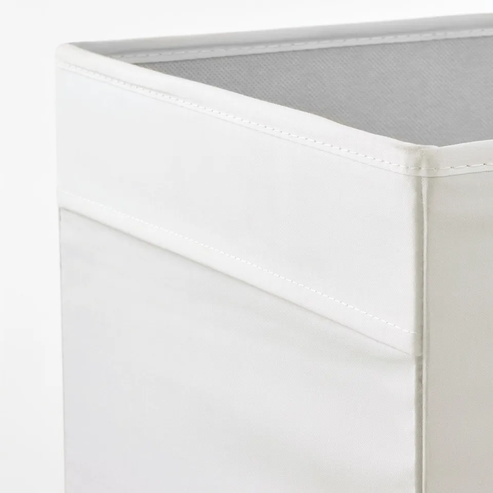 A close-up of a KALLAX white storage box corner, showing its sturdy stitching and clean finish.