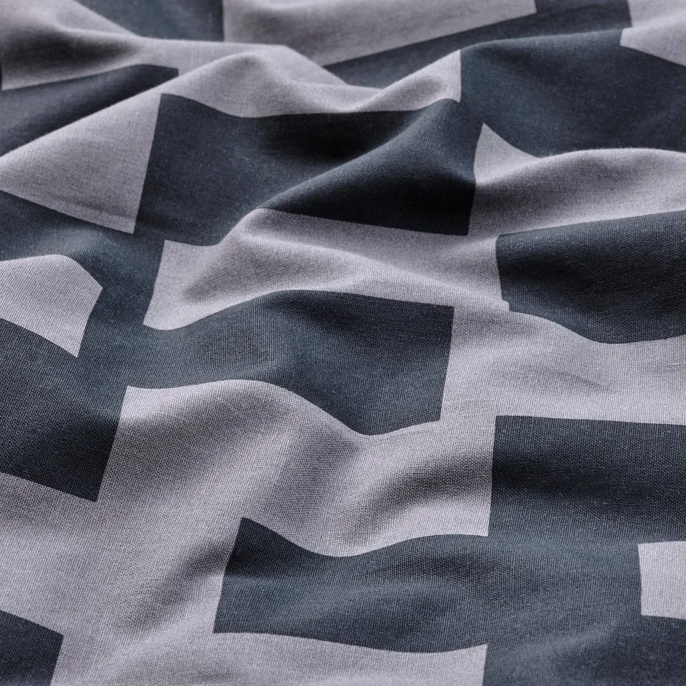 Duvet cover with geometric black and white pattern, made from soft cotton-viscose mix with a subtle sheen, ensuring comfort and breathability.