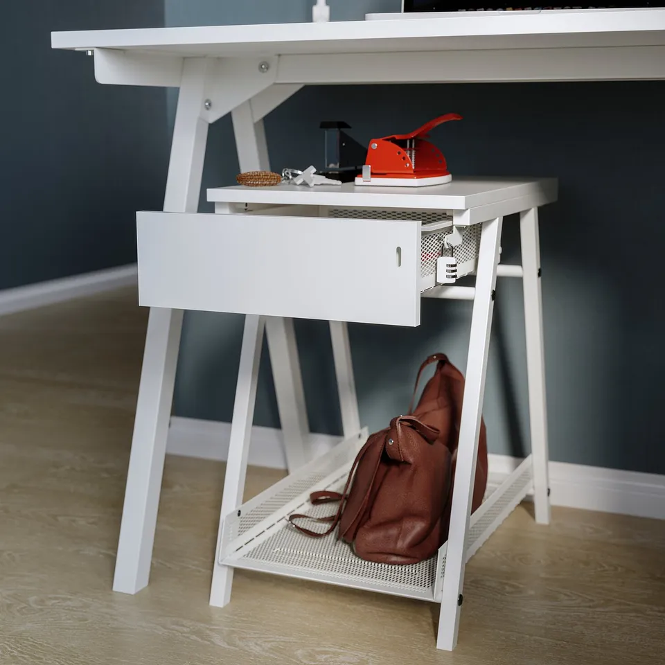 White TROTTEN storage unit with open shelf and lockable drawer, holding red tool and brown bag.
