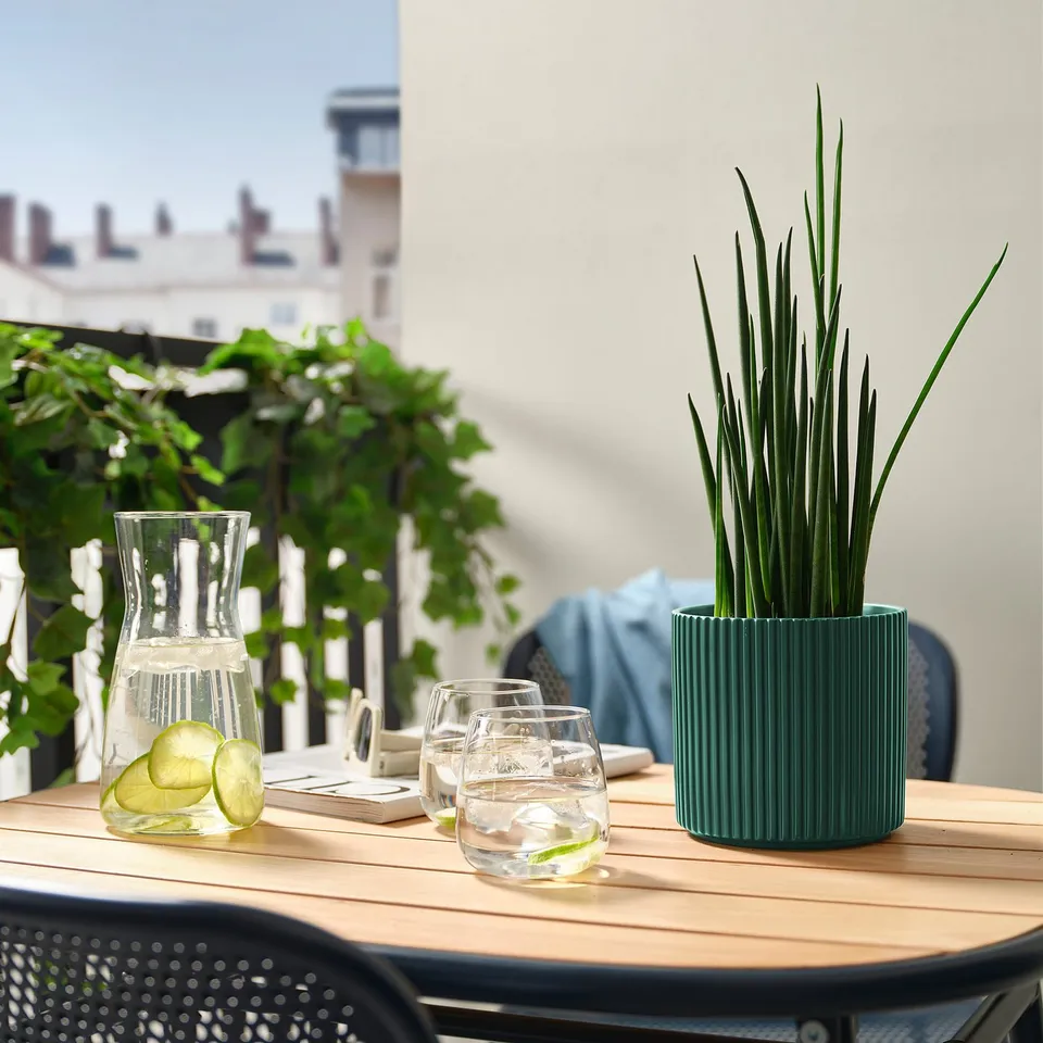 Patio table with water pitcher, lime glasses, and green DAKSJUS planter.