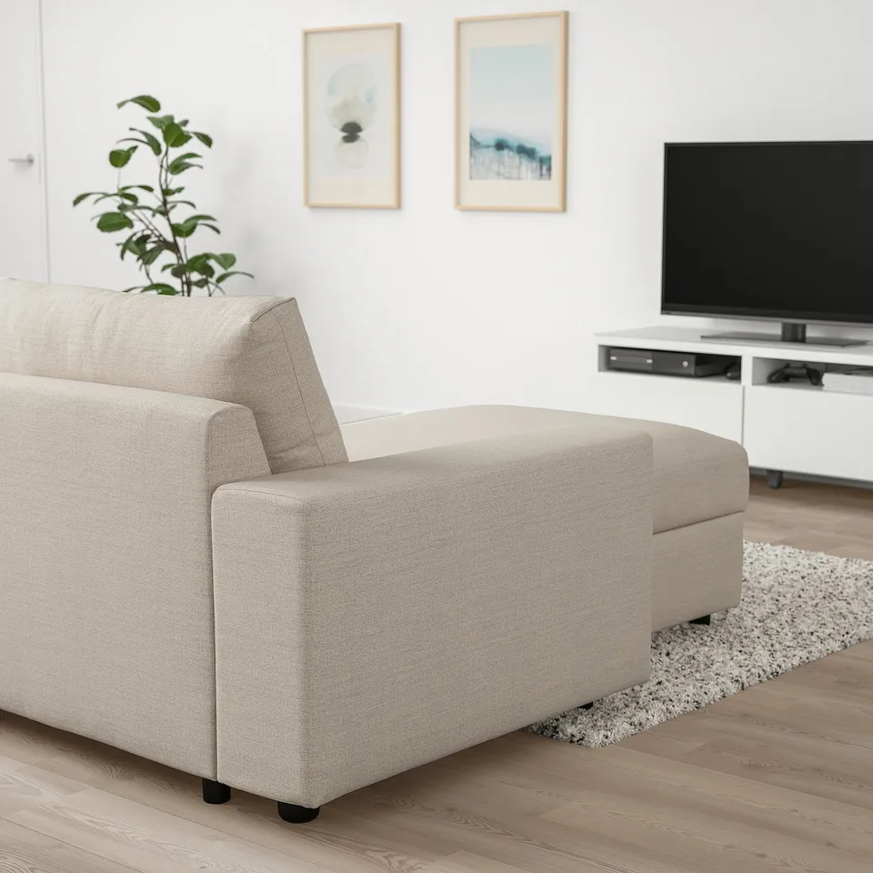 Modern living room with VIMLE beige sofa, green plant, white tv stand,flat screen tv, and wall art.