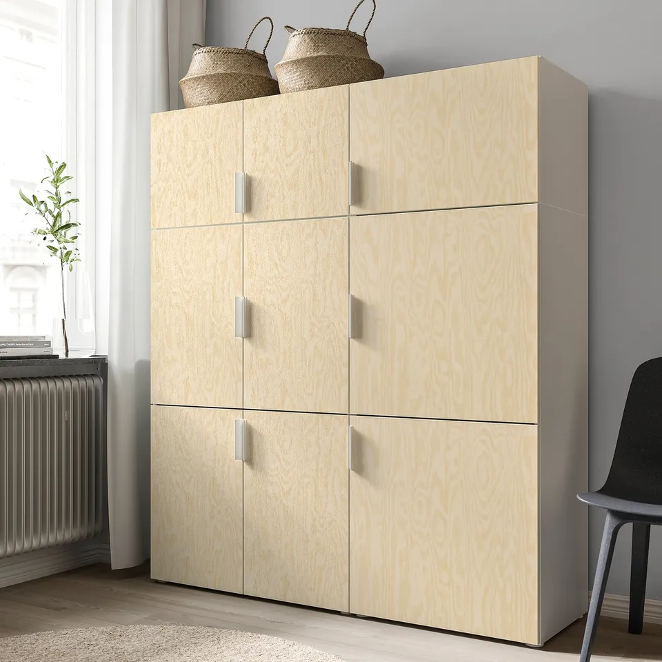 Light wooden storage unit with six doors. Top has two woven baskets. Located in a minimalist room.