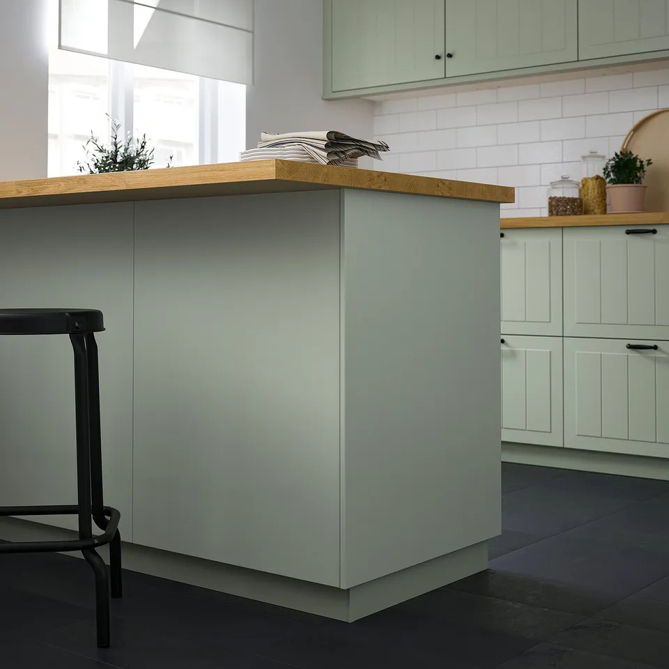Modern kitchen STENSUND green cover panel, fiberboard with acrylic paint, sleek rectangular design, larger than stool, complementing cabinets.