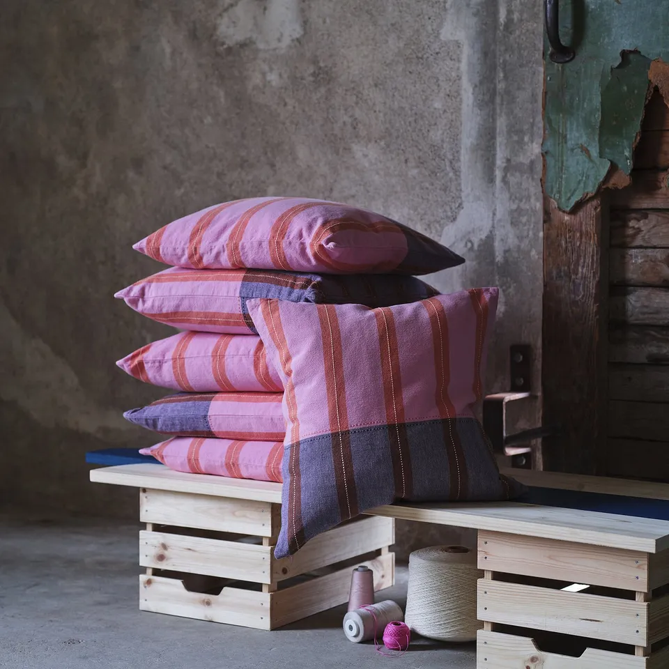 Pink/purple striped pillows on crates with yarn