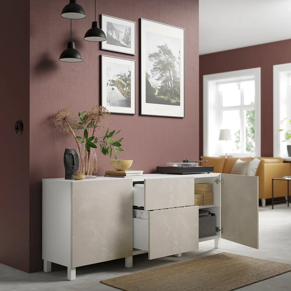Modern living room with BESTÅ cabinet, open doors revealing storage; two pendant lights and framed art decorate above.