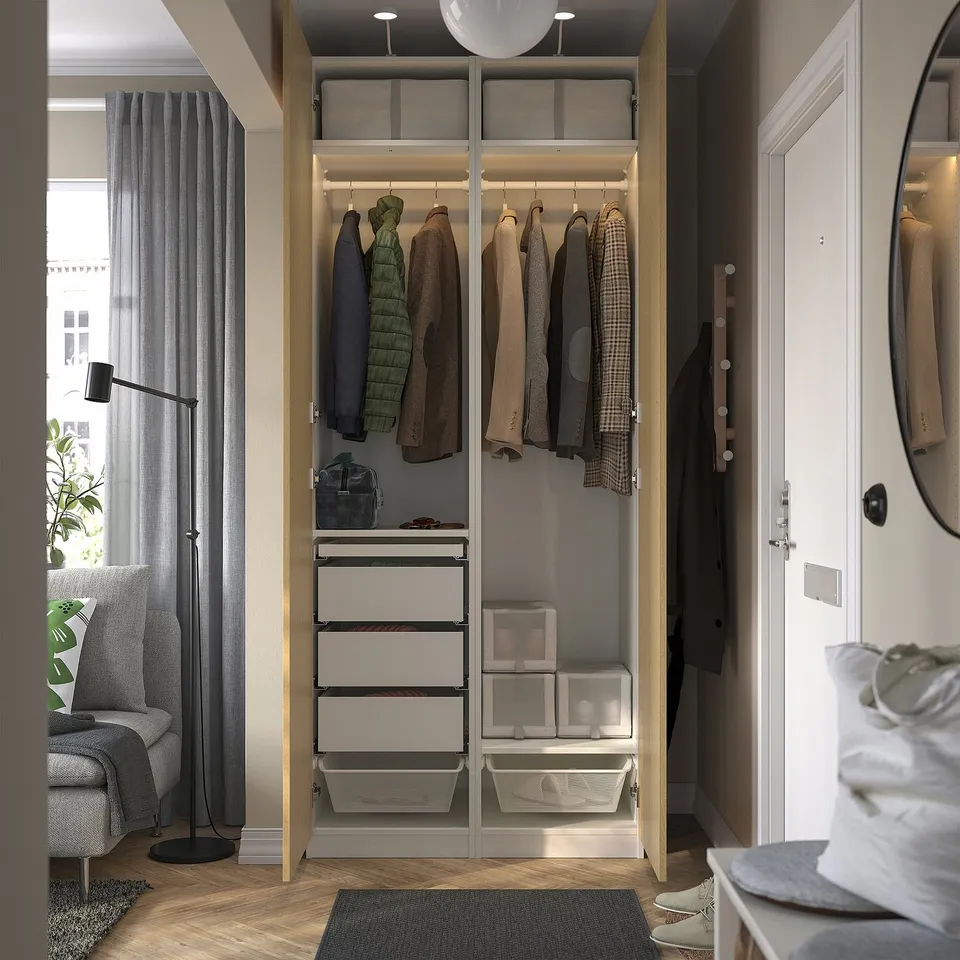 Open wardrobe displaying clothes, drawers, and organised storage with integrated lighting.