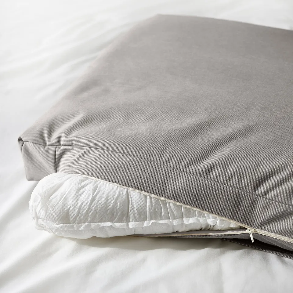 Fluffy pillows on upholstered bed frame, inviting for comfort and reading.