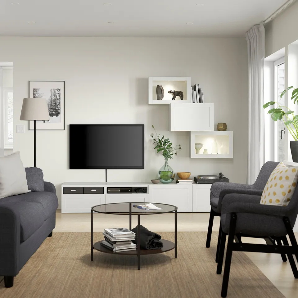 Modern living room with white SINDVIK storage, grey sofa, round glass coffee table, and tv.
