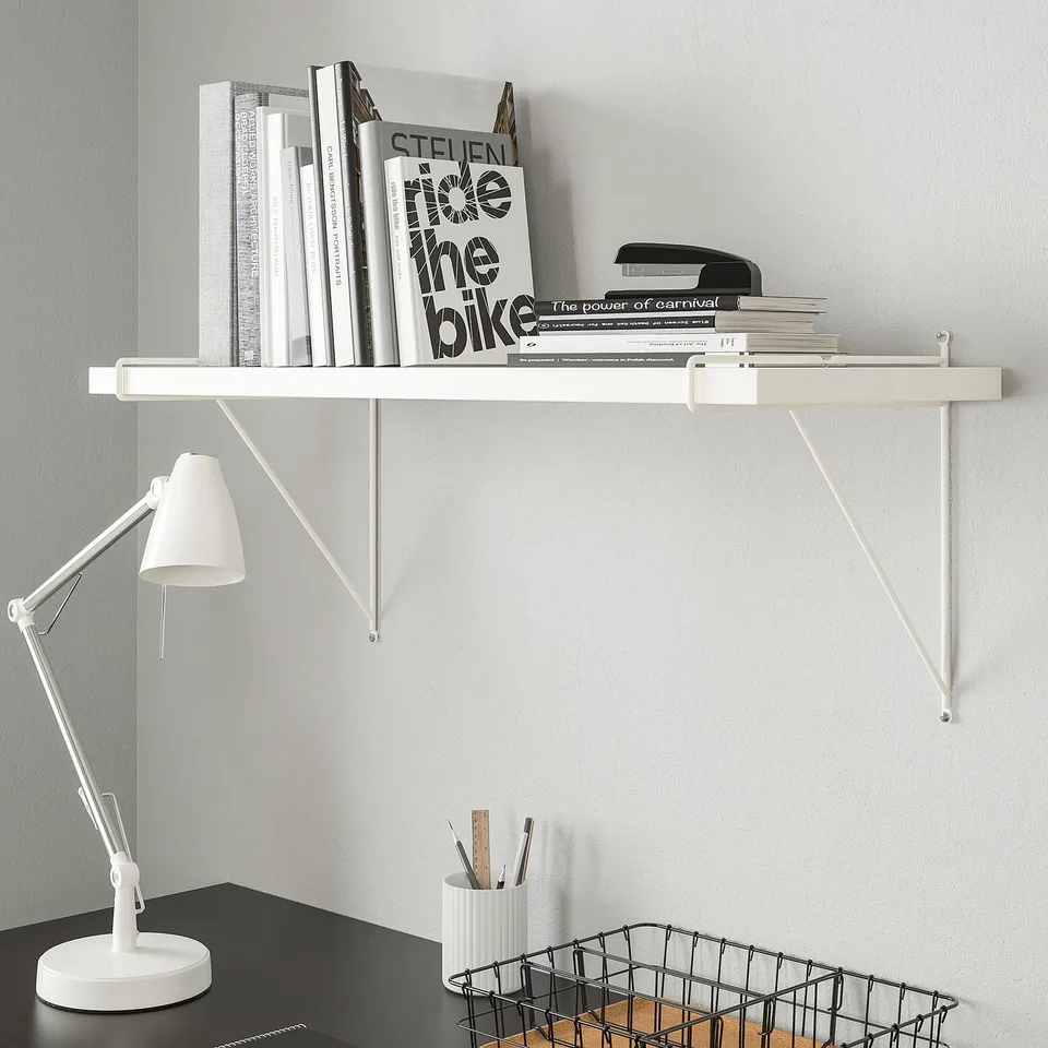 BERGSHULT white wall shelf holds books, lamp, & basket. Shelf appears mid-sized relative to items.