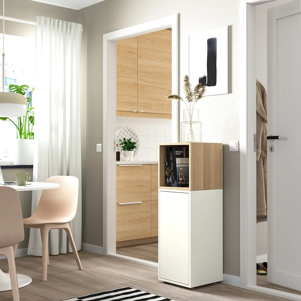 Scandinavian living room: light wood floor, light furniture, large white cabinet, minimalist art.