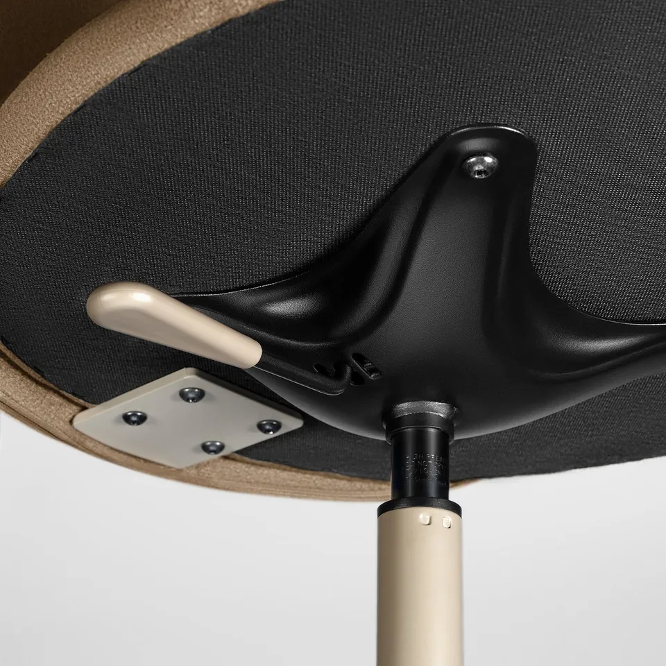 Underneath upholstered swivel chair, showing sturdy metal base and adjustable feet for stability.