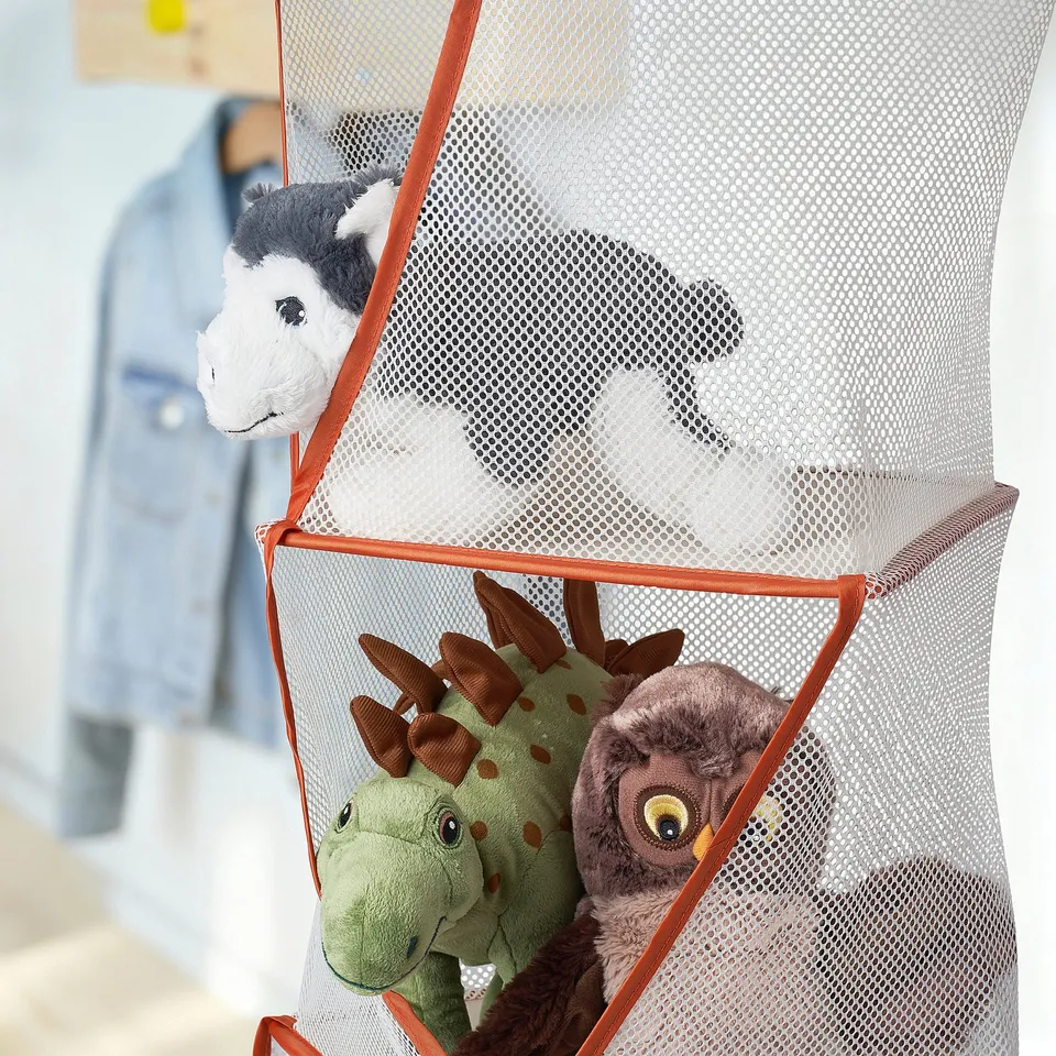 Mesh toy organiser with 5 compartments, holding dinosaur & owl toys. Transparent fabric with orange trim, hangs for easy access.