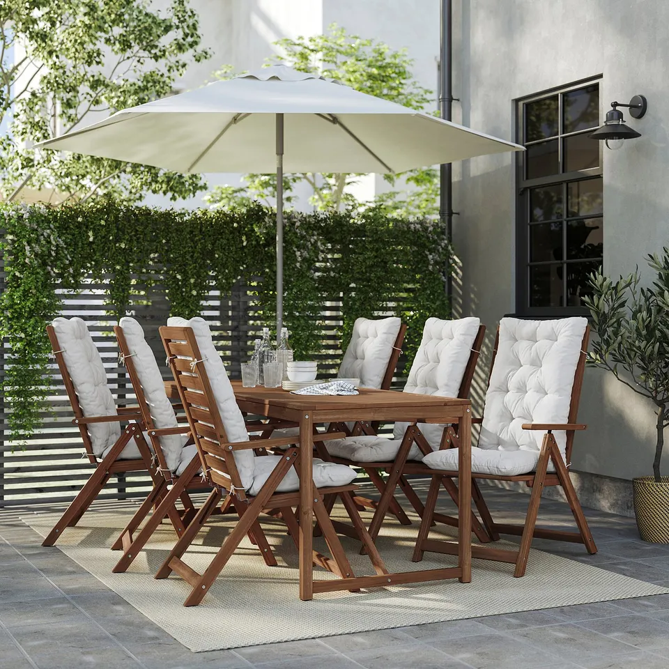 Outdoor patio with beige NÄMMARÖ dining set and cream umbrella. Six acacia wood chairs with cushions.