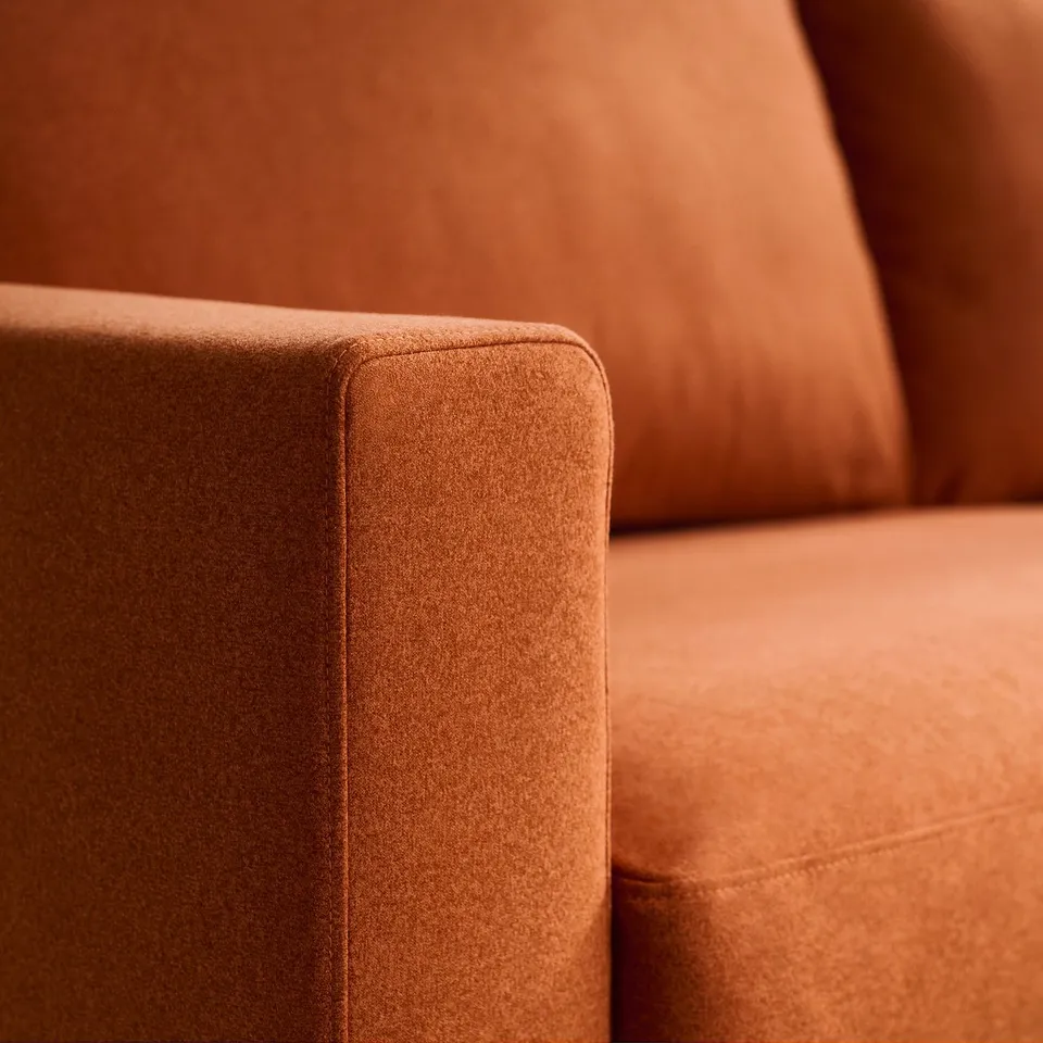 Close-up of a modern brown sofas armrest, showcasing its plush, clean-lined design and high-quality fabric.