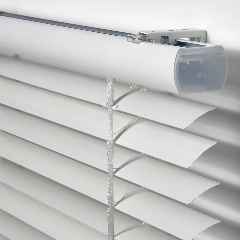 Close-up of modern white venetian blinds. Shows adjustable slats and cord mechanism, mounted securely for safety.