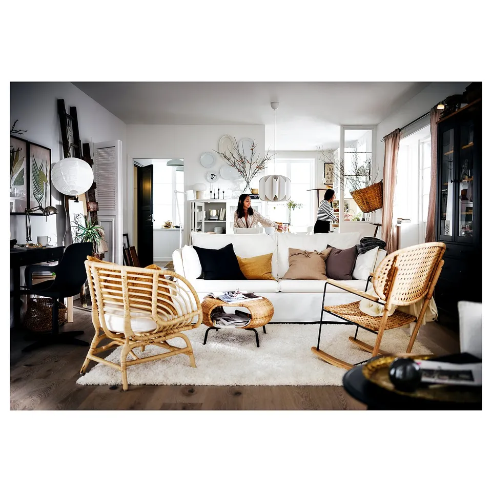 Stylish living room with white shaggy rug, wicker chairs, and bright natural light.