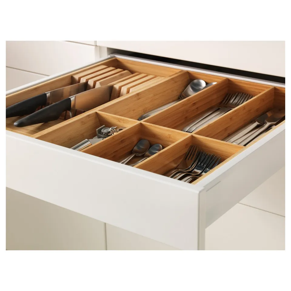 Open kitchen drawer with bamboo cutlery trays, showing organised utensils.