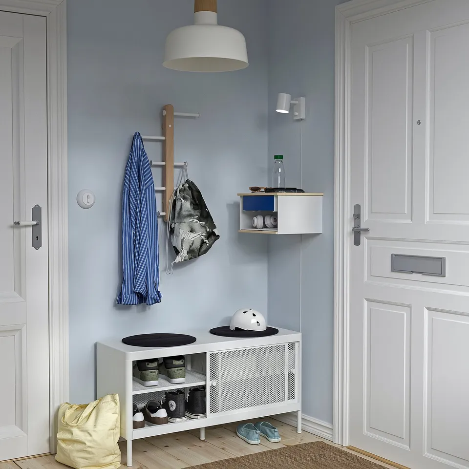 Minimalist STOMSÖ storage: small, stylish, white & mixed materials, open shelves on top, reversible blue/wood drawer, ideal for small spaces.