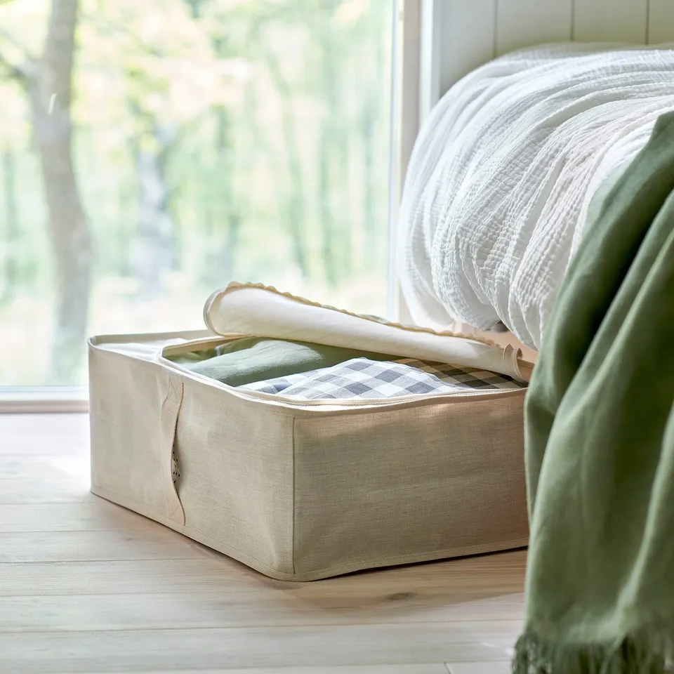 Storage box under bed, holding folded blankets. Easy access with handles, part of the PURRPINGLA series.