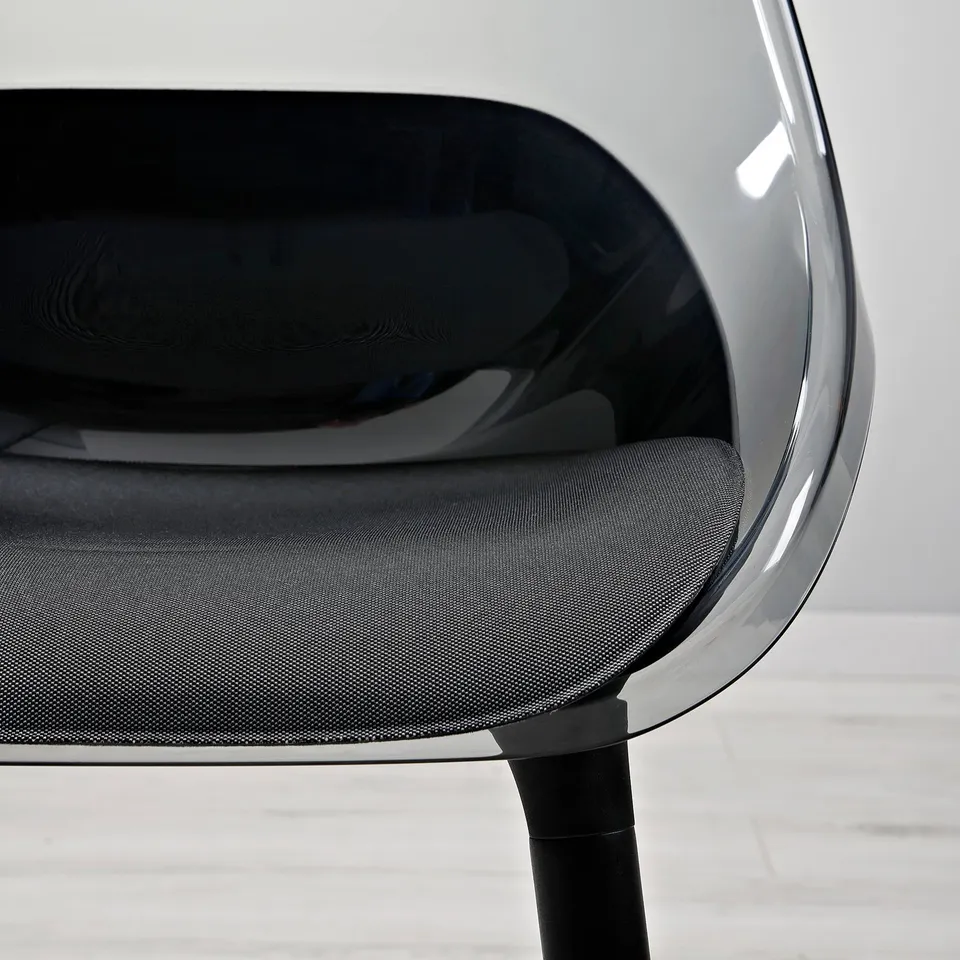 Close-up of a sleek, modern chair with a smooth, clear seat shell and cushioned seat, supported by sturdy wooden legs.