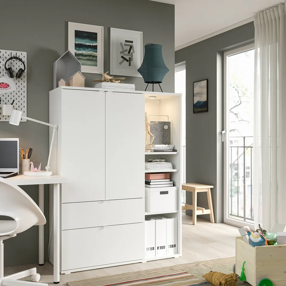 Modern home office with white VIHALS storage unit, grey walls, and large window.