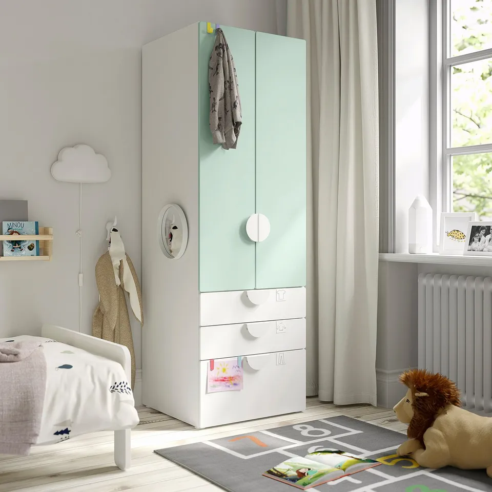 Green SMÅSTAD wardrobe with toy on play mat.