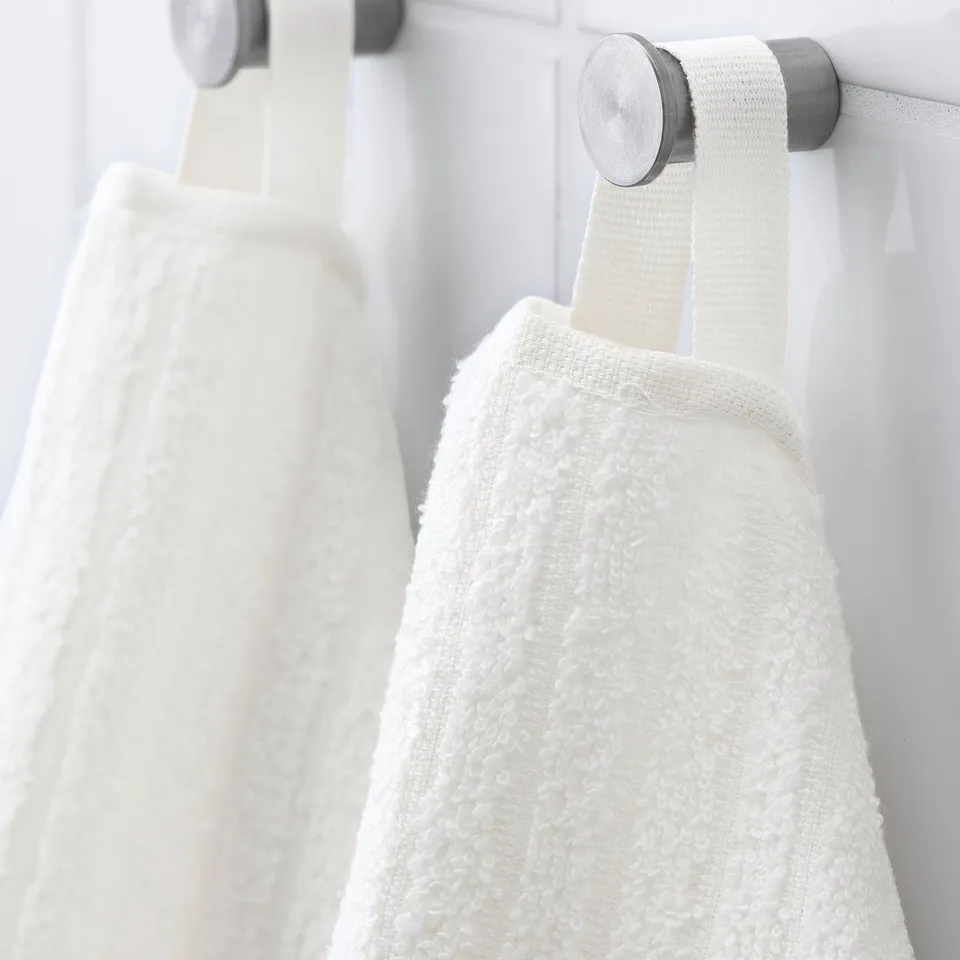 White towels hang neatly from silver hooks. Thick, soft terry material for absorption. Each has a woven stripe, promoting quick drying.