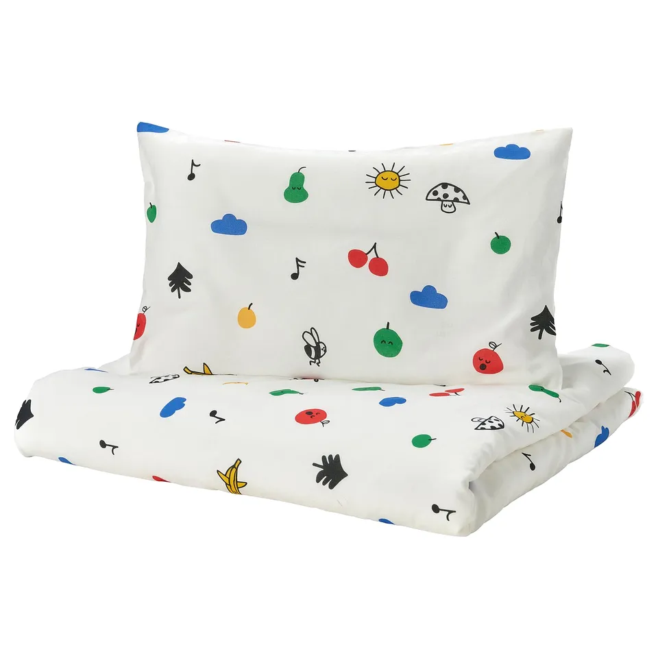 A white IKEA GRÖNFINK toddler duvet set with a colourful fruit and animal pattern.