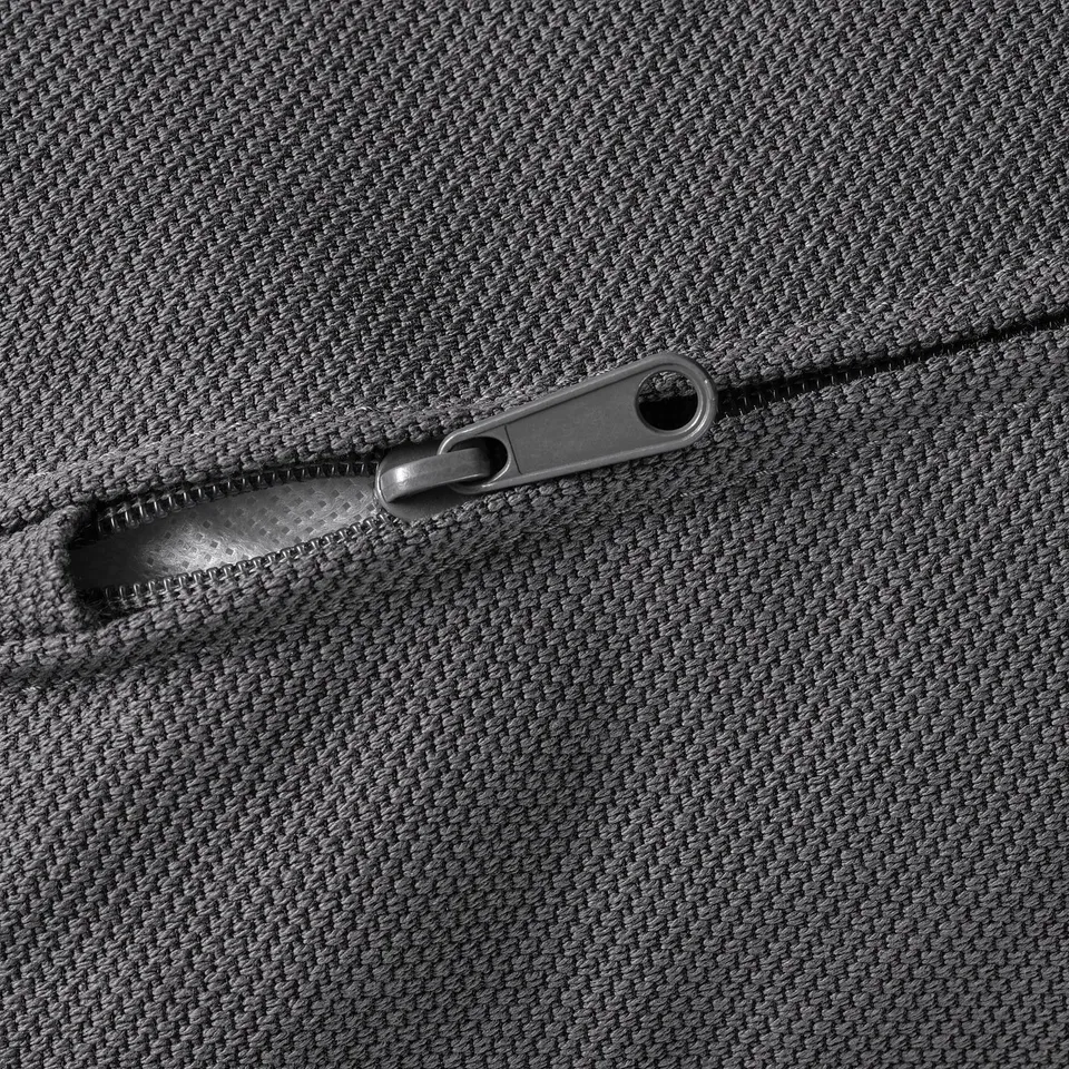 A close-up of a high-quality zip on a textured, grey fabric.