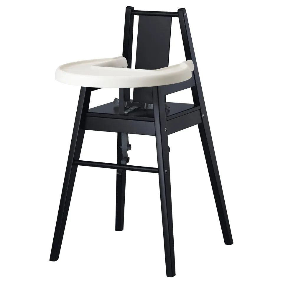 Black highchair with white tray, made of solid wood and plastic, designed for kids to sit safely at the table.