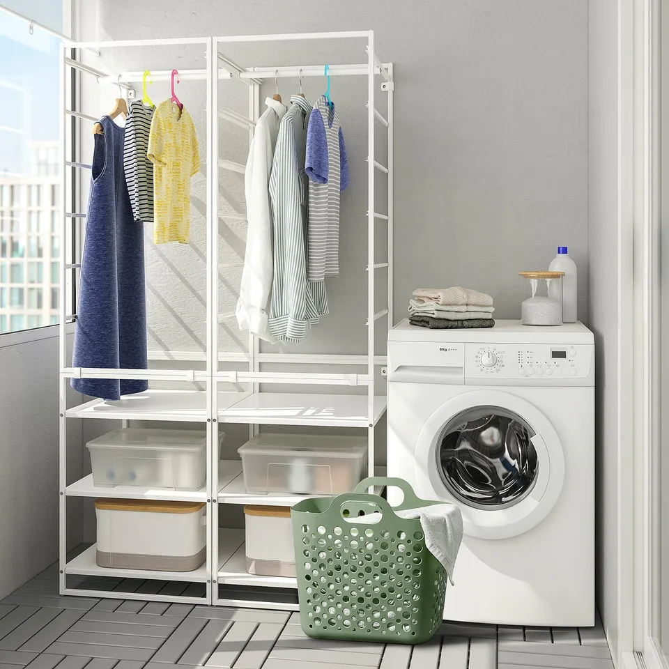 Modern laundry room with white washing machine, drying rack holding clothes, and green mesh laundry basket.