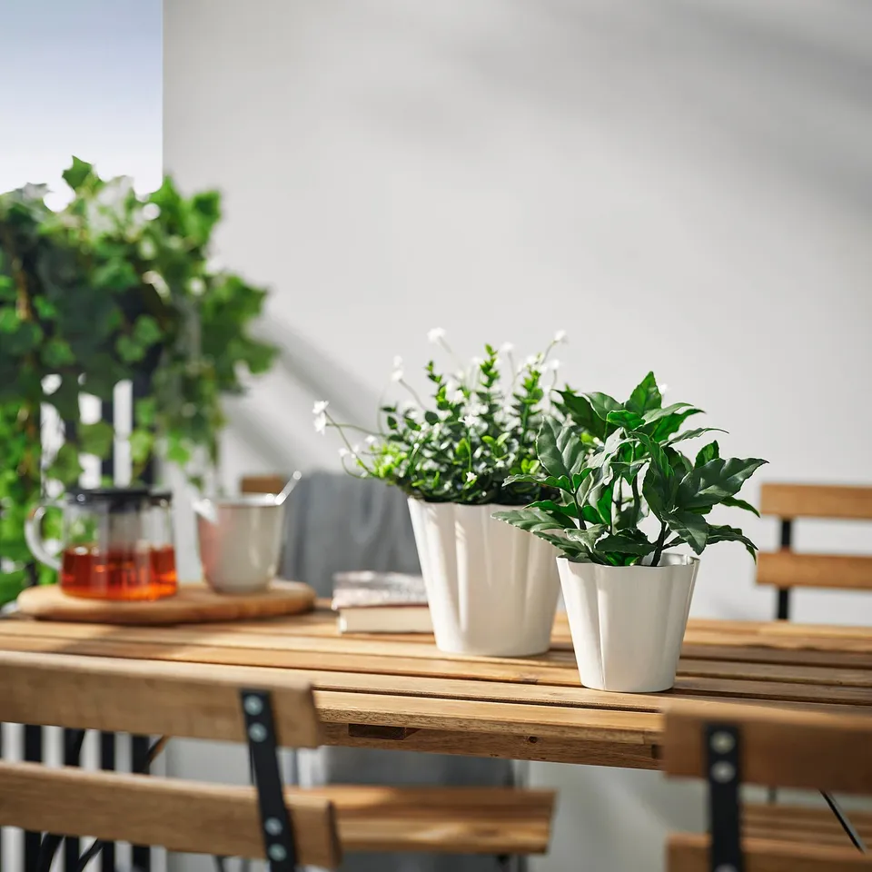 Wooden table with KVASTSPIREA plant pot and green plant. Traditional design, ideal for indoor decor.