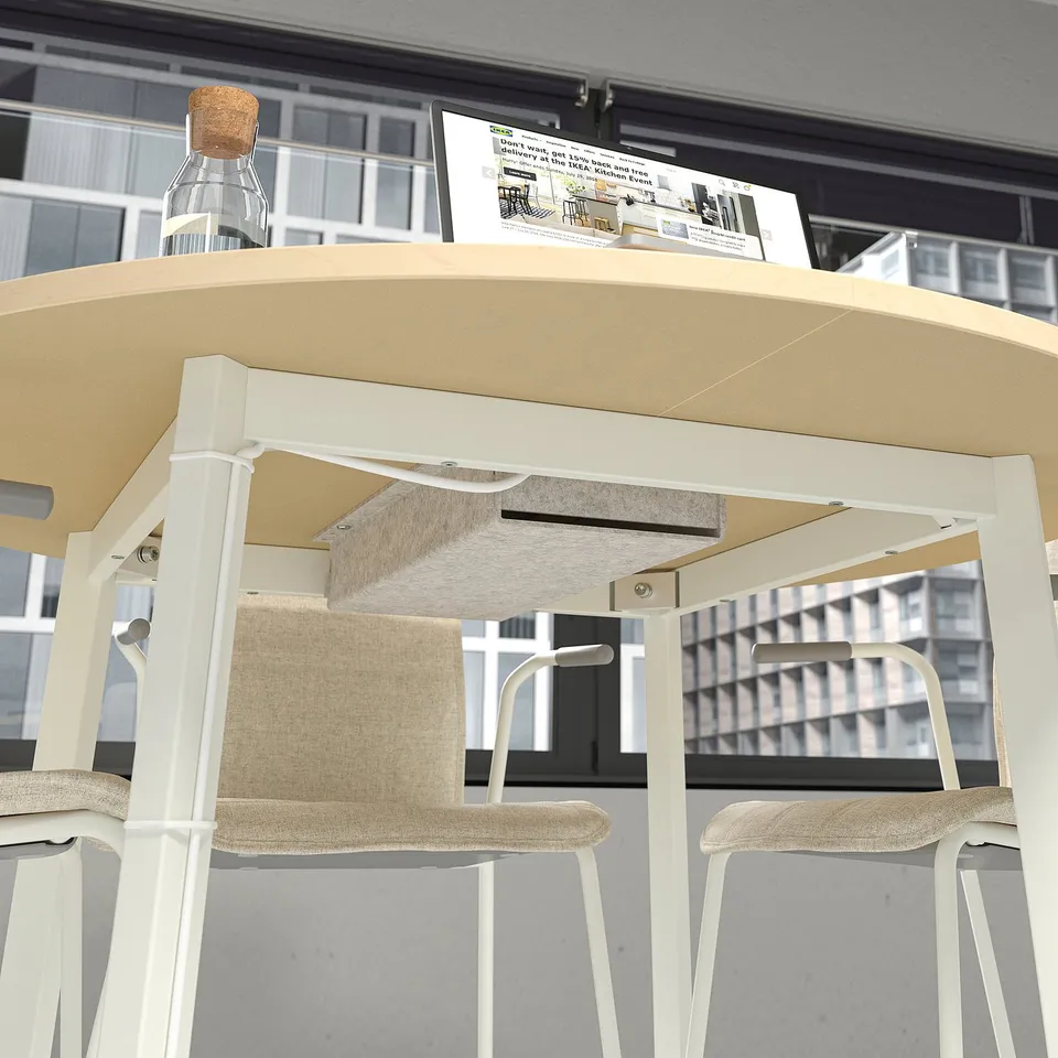 Round conference table with stools and a bottle, ideal for small meetings. Includes a cable management tray.