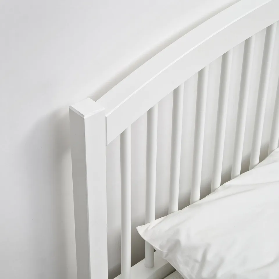 High quality white wooden bed frame with smooth finish, sturdy spindles, and minimalist design.