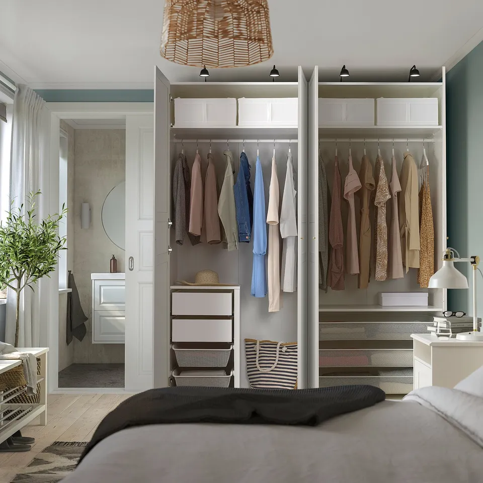 Open wardrobe displaying neatly hung clothes, shelves, and storage boxes. Integrated lighting highlights the organised interior.
