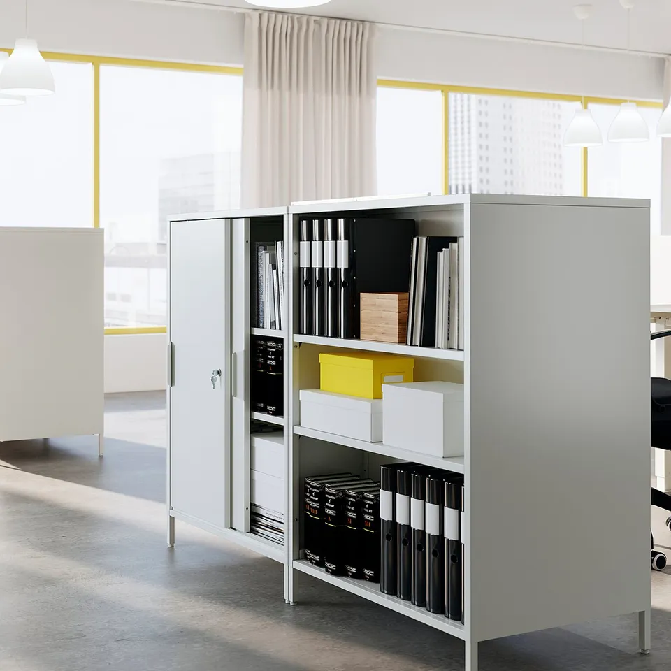 Grey TROTTEN storage cabinet with sliding doors and files in a bright room.