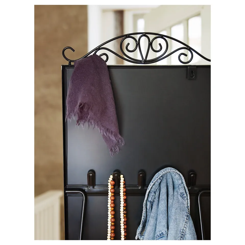 A black mirror with decorative hooks holds a purple scarf and a string of beads. Part of KARMSUND series, it serves as a coat rack and organiser.