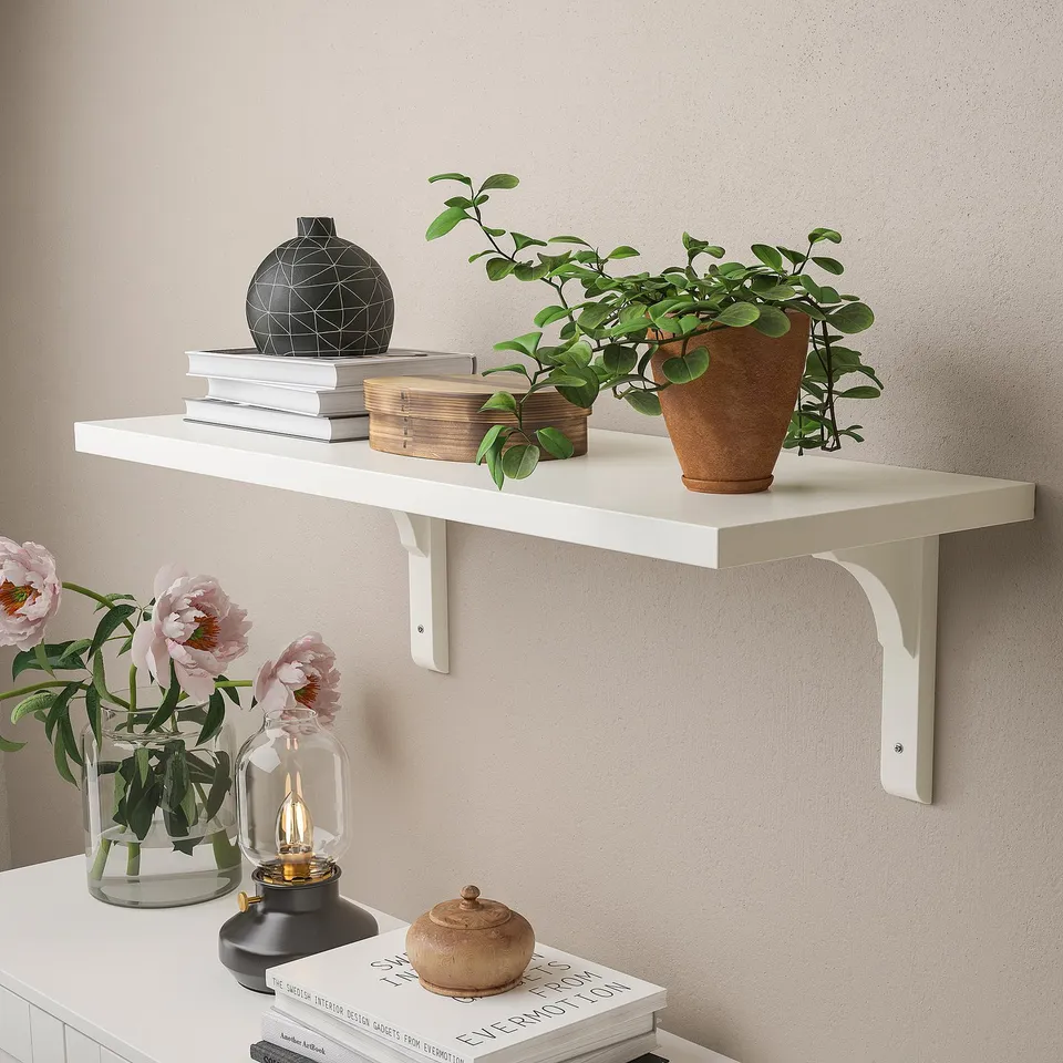 Wall shelf BERGSHULT holds books, plants, and flowers. White, with bevelled & smooth edges, supports up to 10kg.