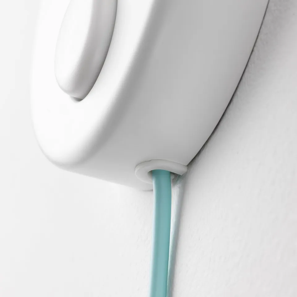 White childrens lamp seen from above, with a turquoise cord and a smooth, curved design.