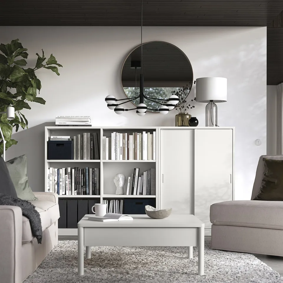 Modern living room with TONSTAD off-white furniture: shelves, cupboard, sofas, coffee table, and decorations.