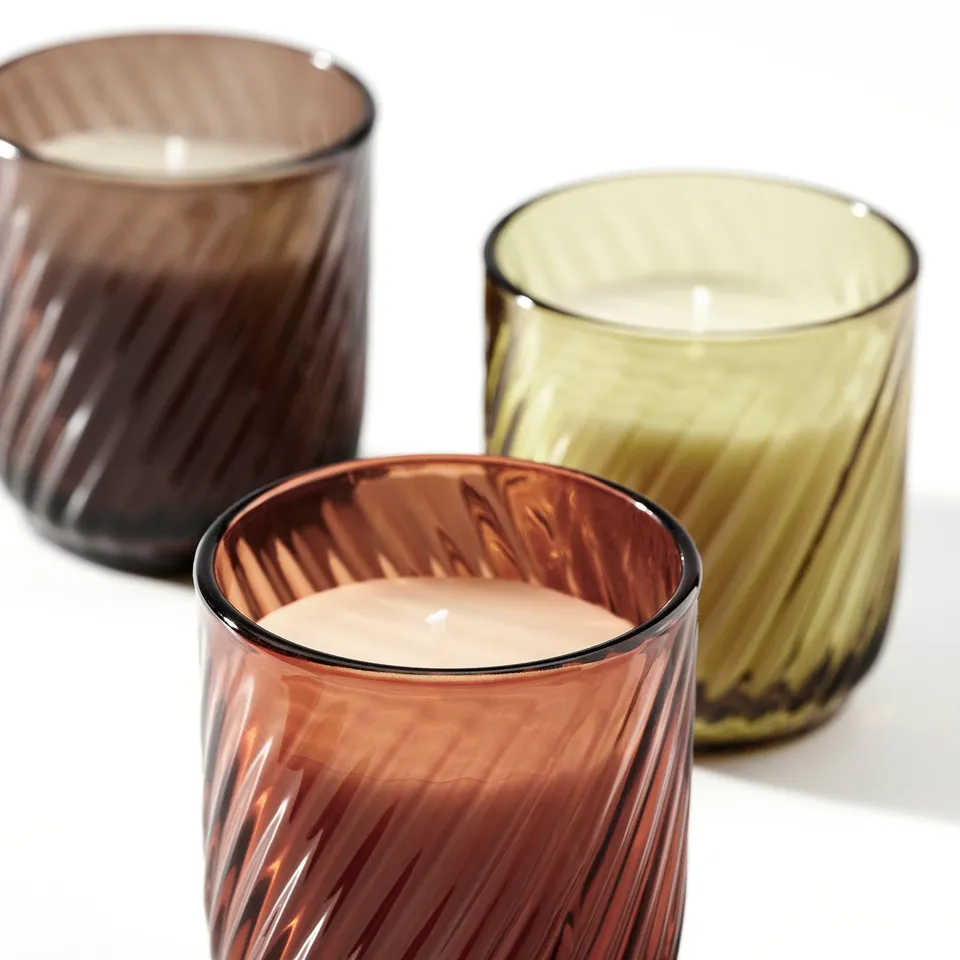 Three textured glass candles in amber, green, and brown with vanilla plant-based wax.