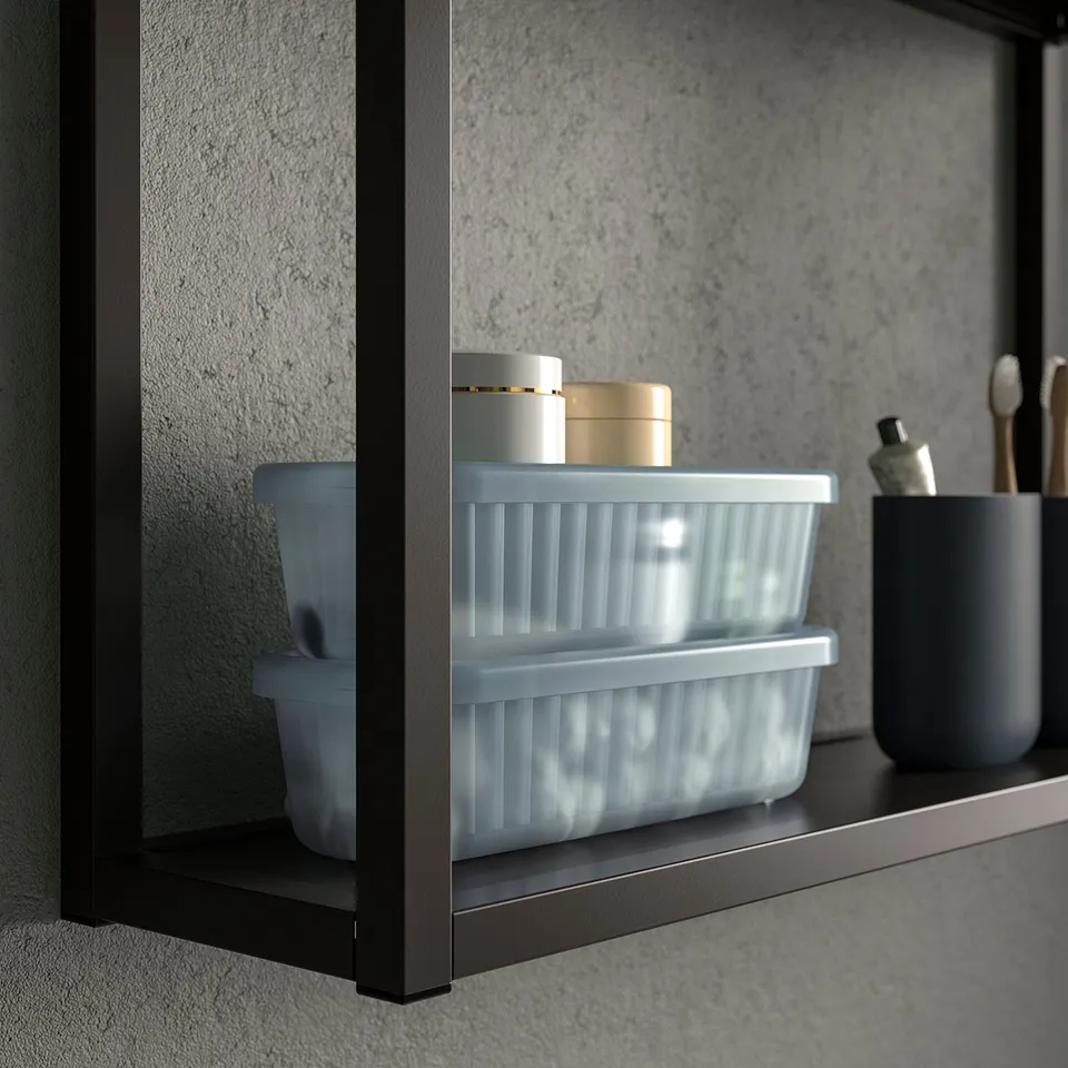 A bathroom shelf with a clear plastic storage box, holding small containers, demonstrating organisation and easy visibility of items.
