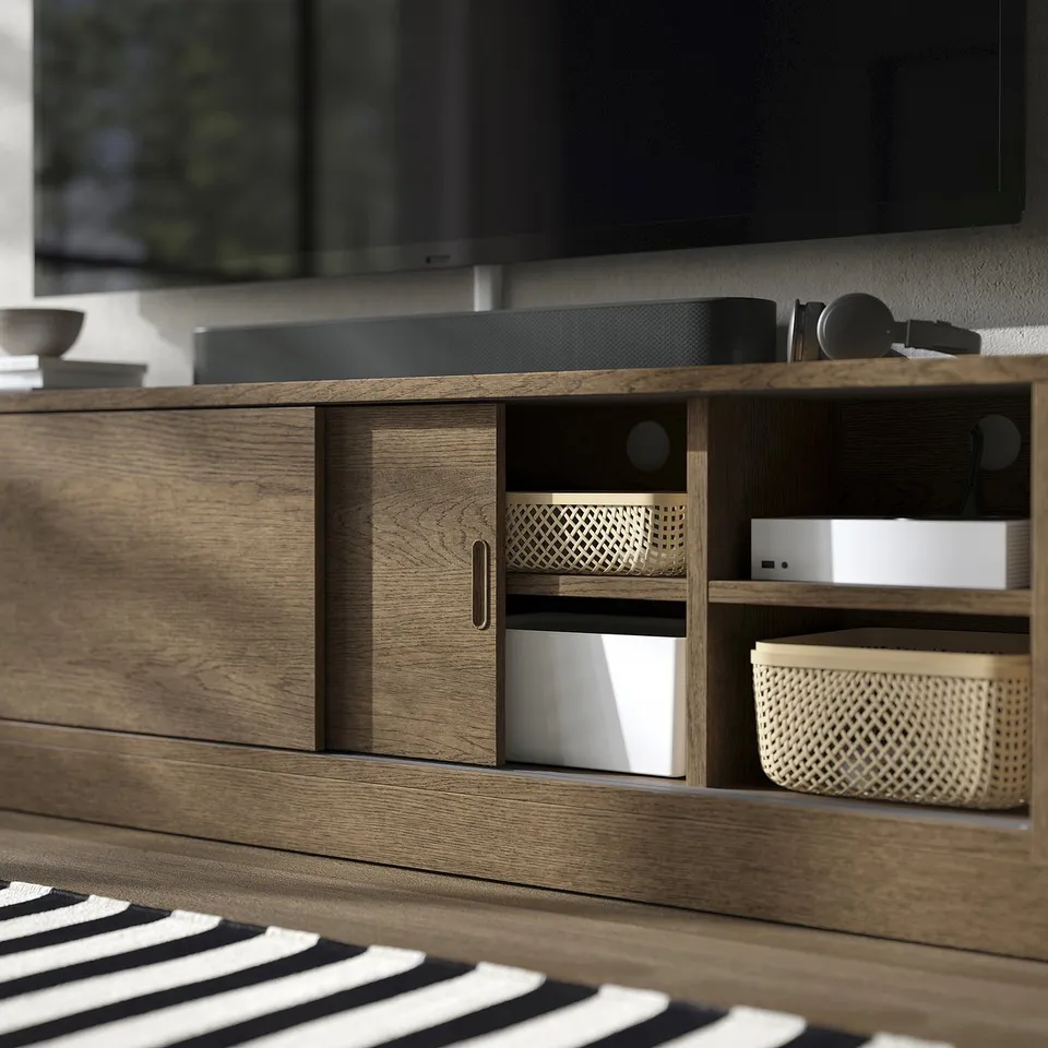 Wooden tv stand with shelves and drawers, housing electronics and storage bins, showing cable management and soft-close.