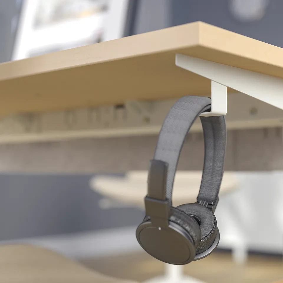 Headphones hang from desk hook. Desk elevates height for comfort.