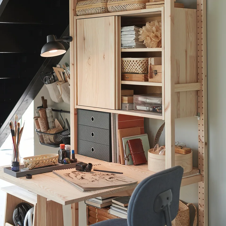 IVAR storage unit with shelves, drawers, books, plants, crafts, foldable desk, adjustable lamp.